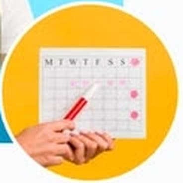 Hand marking a date on a weekly calendar